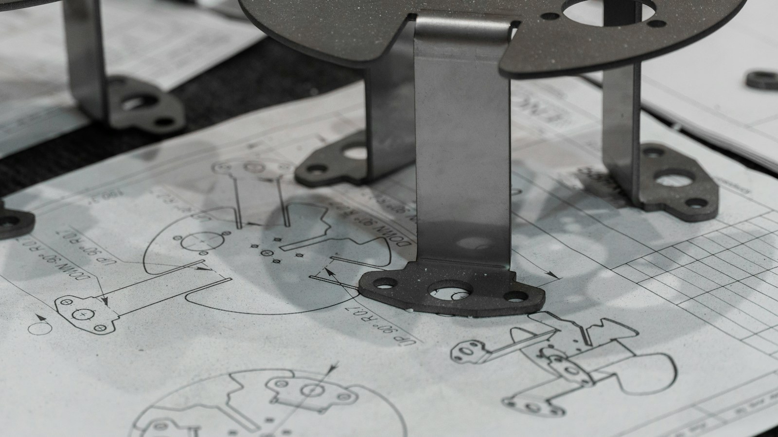 Sheet-metal parts resting on their engineering drawings